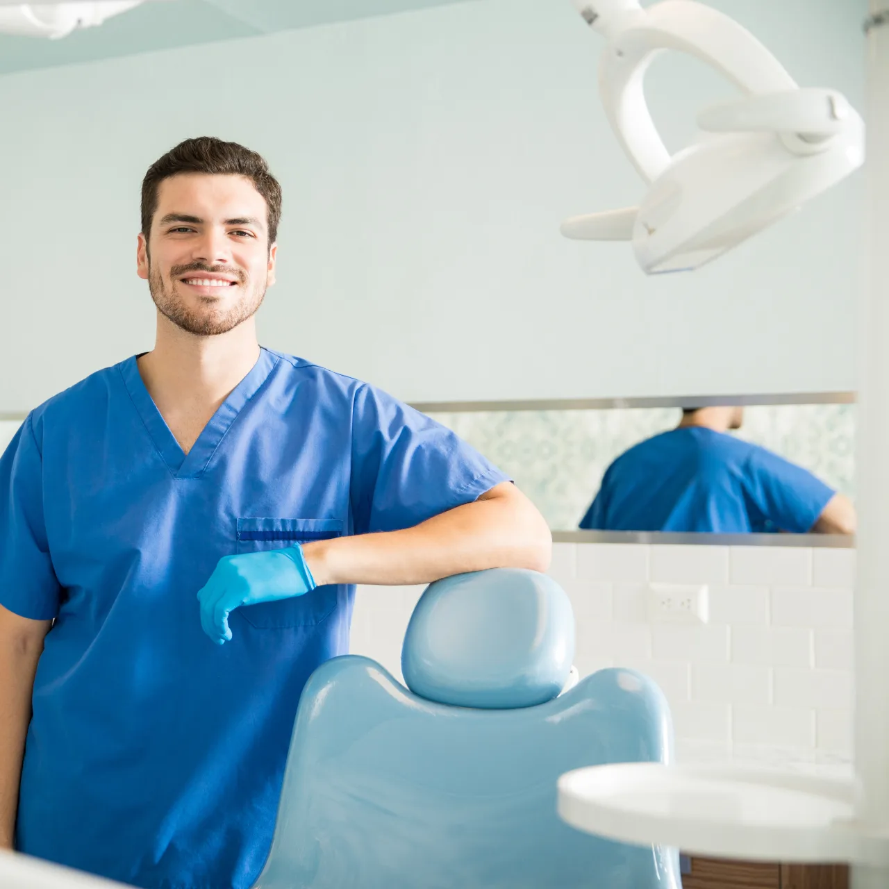 Dentist standing beside a dental chair